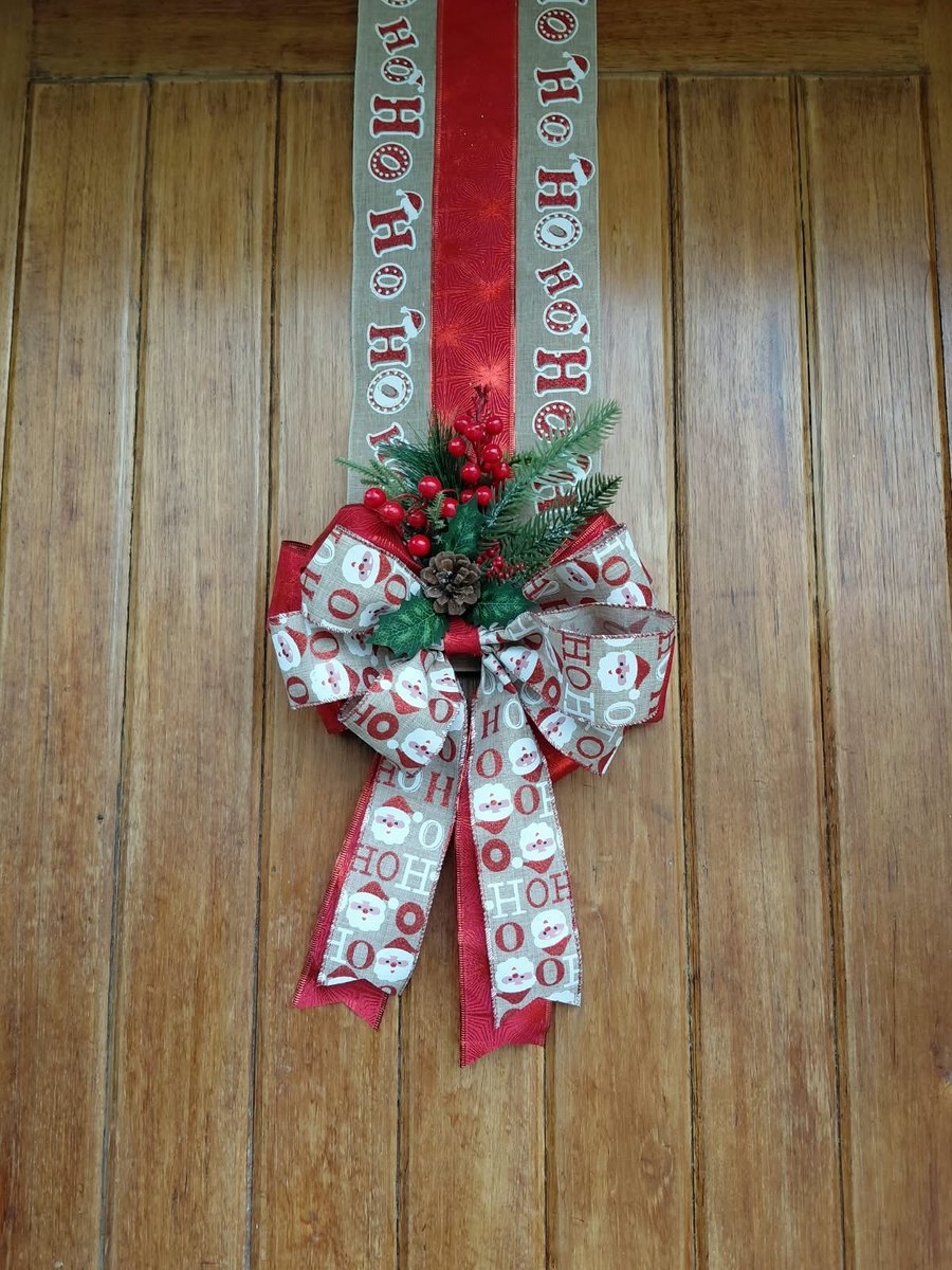 Escapulario de yute con Ho Ho y franja roja, con moño de caritas de Papá Noel